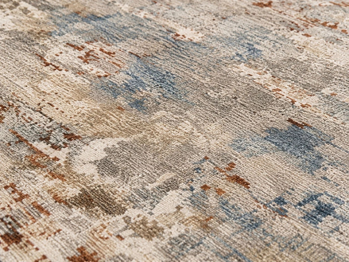 Close-up of the faded beige, blue and gray distressed texture on the rug